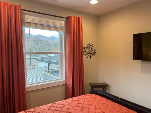 a bedroom with a bed and a window with a view at Urban Retreat Downtown Gem Walk Everywhere Train View Mountain View Near National Park Entrance in Bryson City