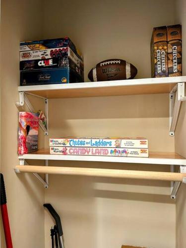 a shelf in a room with books on it at Urban Retreat Downtown Gem Walk Everywhere Train View Mountain View Near National Park Entrance in Bryson City