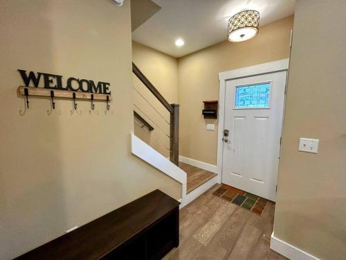 a hallway with a welcome sign next to a door at Urban Retreat Downtown Gem Walk Everywhere Train View Mountain View Near National Park Entrance in Bryson City