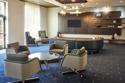 a lobby with a waiting room with chairs and a tv at Courtyard by Marriott Glassboro Rowan University in Glassboro