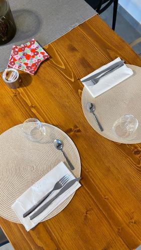 a wooden table with plates and utensils on it at Cascina Ricardin in Coazzolo