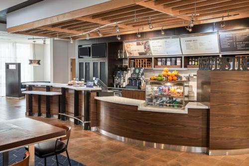 a bar in a restaurant with a counter and tables at Courtyard by Marriott Glassboro Rowan University in Glassboro