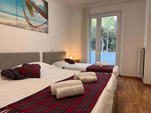 two twin beds in a room with a window at Villa Azzurro Blu in Lignano Sabbiadoro