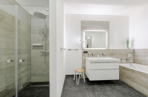 Un baño blanco con lavabo y ducha. en Moderne 5 Sterne Ferienwohnung Strandlilie, en Wustrow