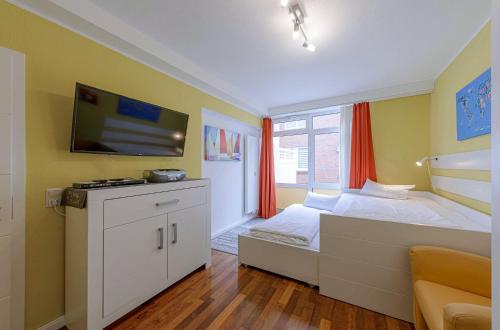 a bedroom with a bed with a tv on the wall at Müritzrast - Apartment mit Terasse und Müritzblick in Waren