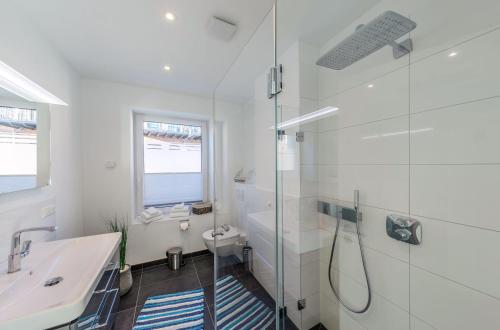 a white bathroom with a shower and a sink at Pusteblume - Barrierefreie 5-Sterne-Ferienwohnung mit Seeblick und Sauna in Malchow
