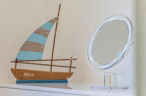 a toy boat sitting on a shelf next to a mirror at Pusteblume - Barrierefreie 5-Sterne-Ferienwohnung mit Seeblick und Sauna in Malchow