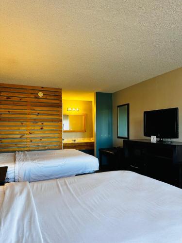 a hotel room with two beds and a flat screen tv at 3 Y Motel in Mount Vernon