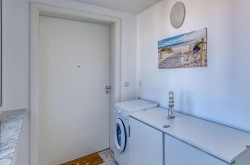 a white laundry room with a washer and dryer at Studio - Modernes Design nahe Müritzstrand & Wellness in Waren