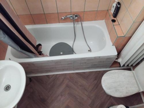 a bathroom with a tub with a toilet in it at Timmy Apartment Ostrovni 4 Prague 1 in Prague