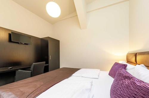 a hotel room with a bed and a flat screen tv at Kietz-Perle mit Balkon & Müritzblick im historischen Speicher in Waren