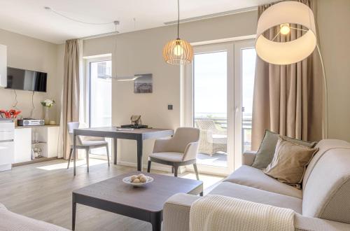 a living room with a couch and a table at Kleine Strandoase - Ferienwohnung mit Südbalkon, Wellness & Boddenblick in Wustrow