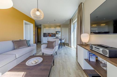 ヴストロにある5 Sterne Ferienwohnung Boddenidylle-modernes Juwel zwischen Ostsee und Boddenのソファとテーブルのあるリビングルーム