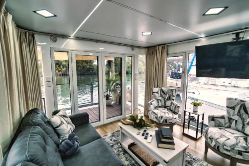 a living room with a couch and chairs and a tv at Unique Houseboat Rental in Merritt Island