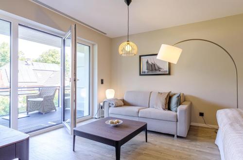 una sala de estar con un sofá y una mesa en Kleine Stranddüne im Strandhaus mit Balkon, en Wustrow