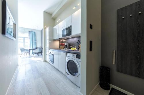 a kitchen with a washing machine in a laundry room at Admiralssuite - Exklusive 5-Sterne-Ferienwohnung mit Westbalkon in der Seefahrtsschule Wustrow in Wustrow