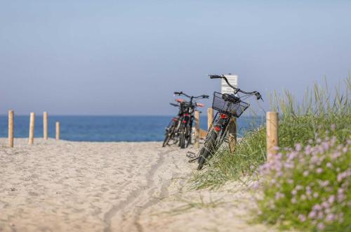 two bikes parked on the sand on the beach at Admiralssuite - Exklusive 5-Sterne-Ferienwohnung mit Westbalkon in der Seefahrtsschule Wustrow in Wustrow