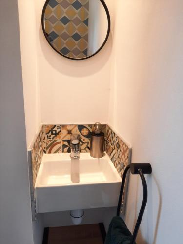 a bathroom with a sink and a mirror on the wall at Logement Indépendant in Gévezé