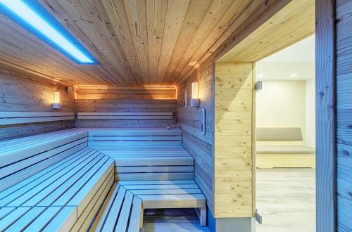 a sauna with wooden walls and a wooden ceiling at Ostseeglück - 5-Sterne-Ferienwohnung mit Südbalkon und Blick zum Saaler Bodden in Wustrow