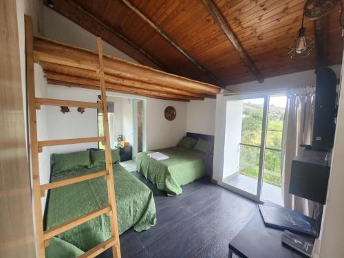 a bedroom with two bunk beds and a ladder at Venado de Oro in Guatavita
