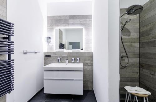 a white bathroom with a sink and a shower at Ostseerast - Urlaub mit Flair auf Fischland-Darß-Zingst in Wustrow