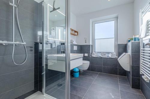 Un baño con ducha, lavabo e inodoro. en Wasserlilie - Stilvolle Ferienwohnung mit Balkon und herzlich willkommenen Vierbeinern, en Malchow