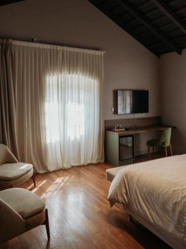 a bedroom with a bed and a desk and a television at Casa Toledo in La Cumbre