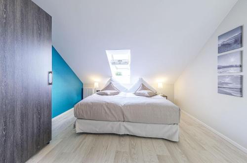 a bedroom with a bed and a blue wall at Seebadrast - 5-Sterne Ferienwohnung mit historischem Charme und modernem Komfort in Wustrow