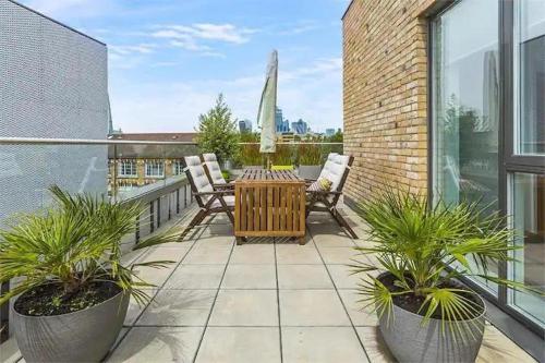 a patio with a table and chairs on a balcony at 2-Bed Terrace Flat Close to Tower Bridge in London
