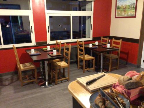 a restaurant with two tables and chairs and windows at Hôtel Bellevue Bagnoles Normandie in Bagnoles de l'Orne