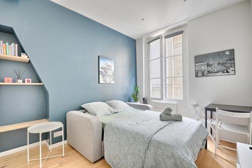 une chambre avec un lit et un mur bleu dans l'établissement Ciseaux 3G - SAINT GERMAIN DES PRES - Superbe appartement, à Paris
