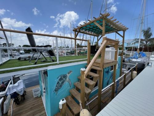 a deck of a boat with a ladder and a turtle on it at Unique Houseboat Rental in Merritt Island