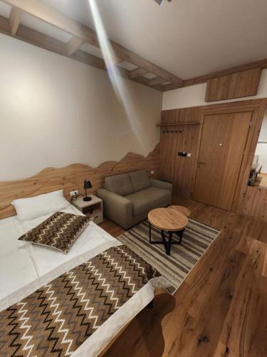 Apartment Vucko C030 Jahorina private host Aparthotel Vucko في ياهورينا: غرفة نوم بها سرير كبير وأريكة