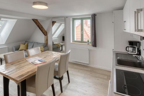 a kitchen and dining room with a wooden table and chairs at City Suite an der Drehbrücke Malchow in Malchow