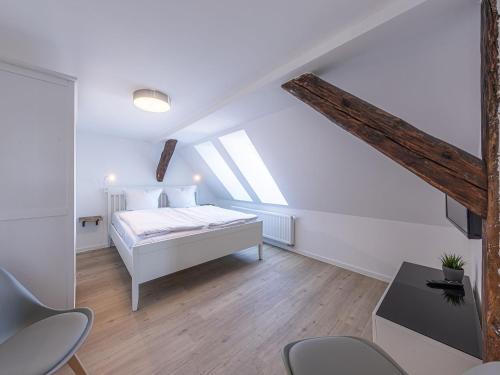 a white bedroom with a bed and some chairs at City Suite an der Drehbrücke Malchow in Malchow