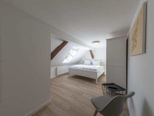 a white room with a bed and a chair at City Suite an der Drehbrücke Malchow in Malchow