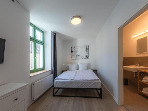 a small bedroom with a bed and a sink at Family Suite im Herzen von Malchow in Malchow