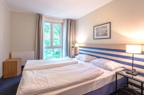 a hotel room with two beds and a window at Strandhafer an der Seebrücke in Zingst