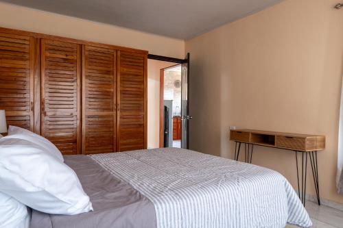 a bedroom with a bed and a wooden closet at Villa Paz in San José