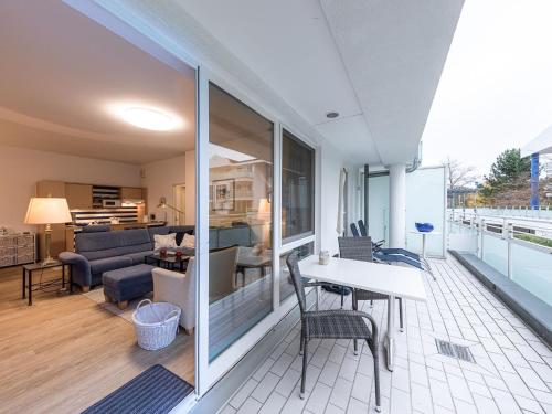 un salon avec une table et des chaises sur un balcon dans l'établissement Bernstein an der Seebrücke Zingst, à Zingst