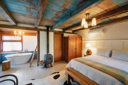 a bedroom with a bed and a tub and a sink at SÍTIO Canjerana em Gramado in Canela