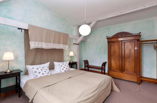 a bedroom with a bed and a wooden cabinet at Rapunzel - Gemütliche Ferienwohnung mit Landhausstil und überdachtem Balkon in Waren