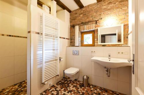 a bathroom with a toilet and a sink at Ferienwohnung Lilie mit Balkon in einer geschmackvoll sanierten Backsteinmühle in Waren