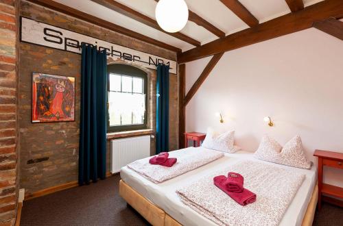 a bedroom with two beds with red towels on them at Ferienwohnung Lilie mit Balkon in einer geschmackvoll sanierten Backsteinmühle in Waren