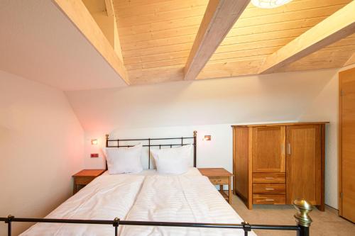 a bedroom with a bed and a wooden ceiling at Kietz-Koje - Ferienapartment mit Müritzblick & Naturgenuss in Waren