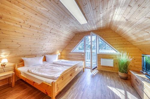 a bedroom with a bed in a wooden room at Leif im Heidepark in Silz