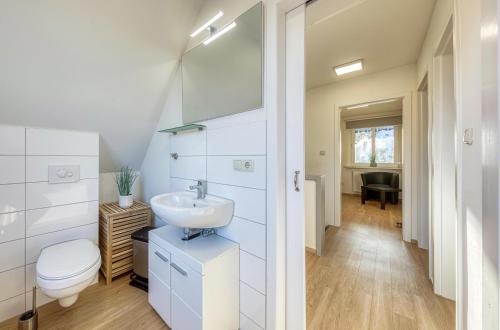 ein weißes Badezimmer mit Waschbecken und Toilette in der Unterkunft Ferienhaus Casa Castagno mit Garten, Balkon und Sauna- heißt Sie herzlich willkommen! in Alt Schwerin