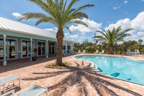 a swimming pool with a palm tree next to a building at Unique Houseboat Rental in Merritt Island