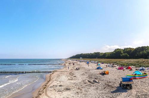 a beach with a lot of people on it at 5 Sterne Ferienhaus Ostseetraum - 50m zum Strand - Ladestation für E-Auto in Fuhlendorf