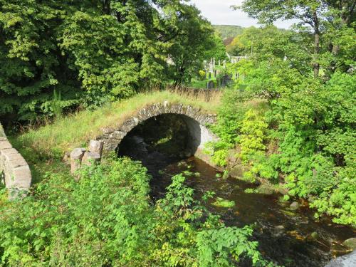 a stone bridge over a river in a forest at Bankhouse B&B in Aberlour